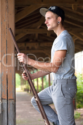 Junger Arbeiter auf der Leiter