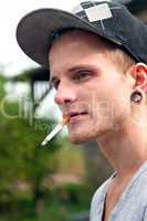 Junger Mann mit Zigarette im Mund