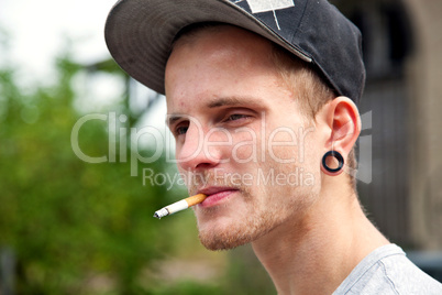 Junger Mann mit Zigarette im Mund