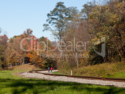 Pair of cyclists ride along railway