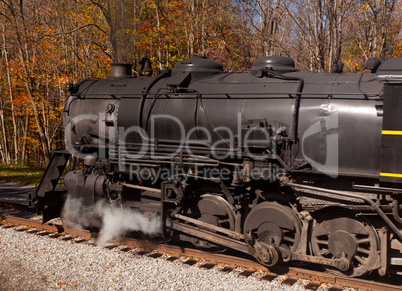 Steam train powers along railway