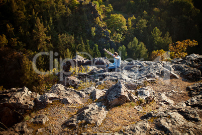 young man using laptop sitting on a rock slope