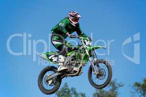 Motorcycle jumping against blue sky