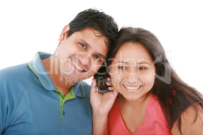 Couple are listening to a friend on a cell phone.