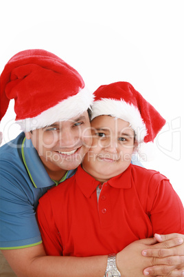 Happy father and son with Christmas hats look to the camera