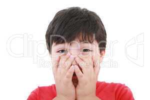 Preschool aged boy with his hand/fists over his mouth; looking e