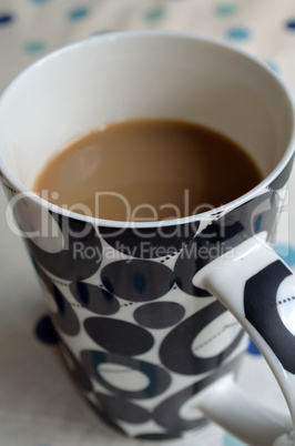 Cup of Coffee in a black and white tall cup with circular pattern