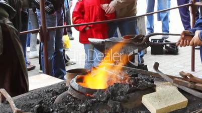 blacksmith puts metal ring on fire