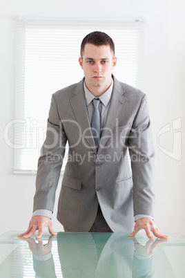 Confident business man behind a table