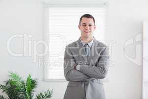 Smiling business man with his arms folded