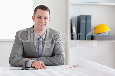 Smiling architect sitting behind a table
