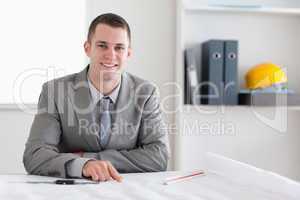 Smiling architect sitting behind a table