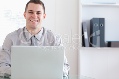 Happy businessman working on his laptop