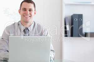 Happy businessman working on his laptop