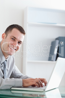 Happy businessman typing on his laptop