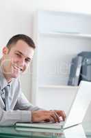 Happy businessman typing on his laptop