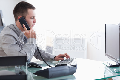 Businessman typing while on the phone