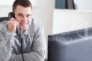 Smiling businessman listening to the telephone