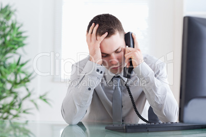 Close up of businessman getting bad news on the phone