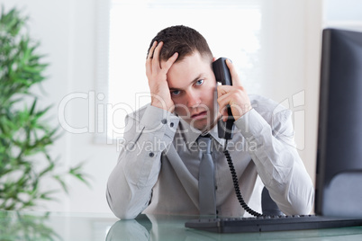Close up of businessman getting sad news on the phone