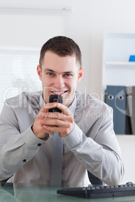 Businessman getting a pleasant text message on his chellphone