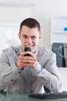 Businessman getting a pleasant text message on his chellphone