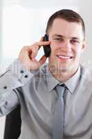 Close up of smiling businessman getting good news on the phone