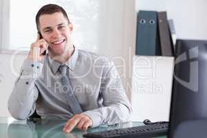 Businessman getting pleasant news on the cellphone