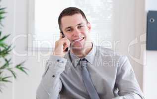 Businessman getting pleasant news on the mobile phone