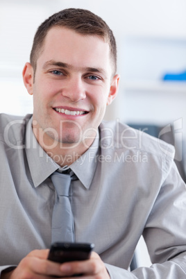 Close up of smiling businessman with cellphone in his hands