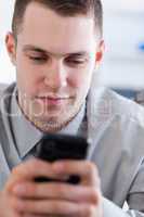 Close up of businessman reading text message on his cellphone