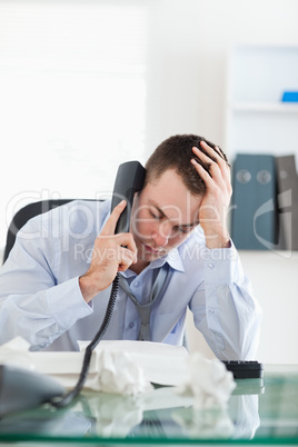 Close up of businessman looking at an invoice while on the phone