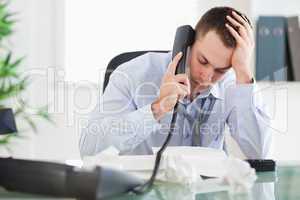 Businessman looking at an invoice while on the phone