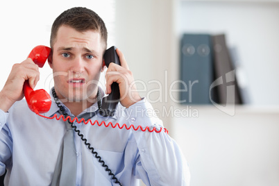 Close up of businessman unable to cope with the telephone