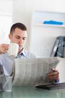 Businessman reading the newspaper and having a coffee