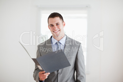 Smiling businessman with open folder