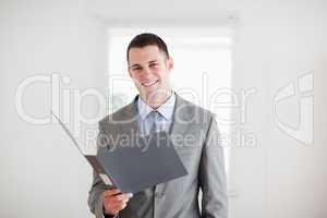 Smiling businessman with open folder