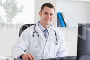Smiling doctor on his computer