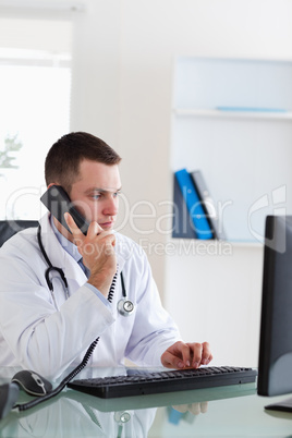 Doctor on the telephone while looking at the screen