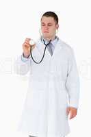 Doctor looking at stethoscope while using it