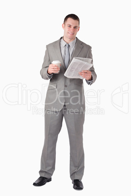 Portrait of a businessman reading the news while holding a cup o