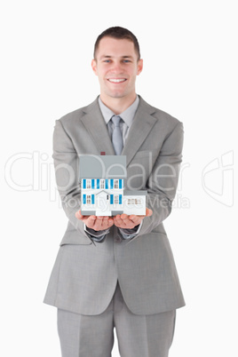 Portrait of a businessman holding a miniature house