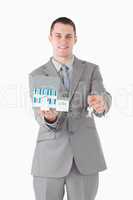 Portrait of a businessman holding a miniature house and keys