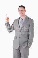 Portrait of a smiling young businessman pointing at something
