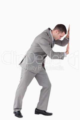 Portrait of a businessman pushing a wall