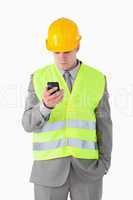 Portrait of a young builder looking at his cellphone
