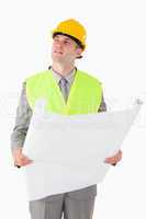 Portrait of a builder looking around while holding a plan