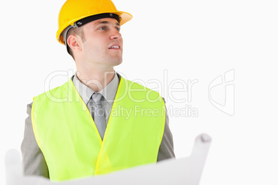 Builder holding a plan while looking around