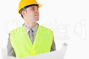 Builder holding a plan while looking around