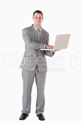 Portrait of a young businessman holding a laptop